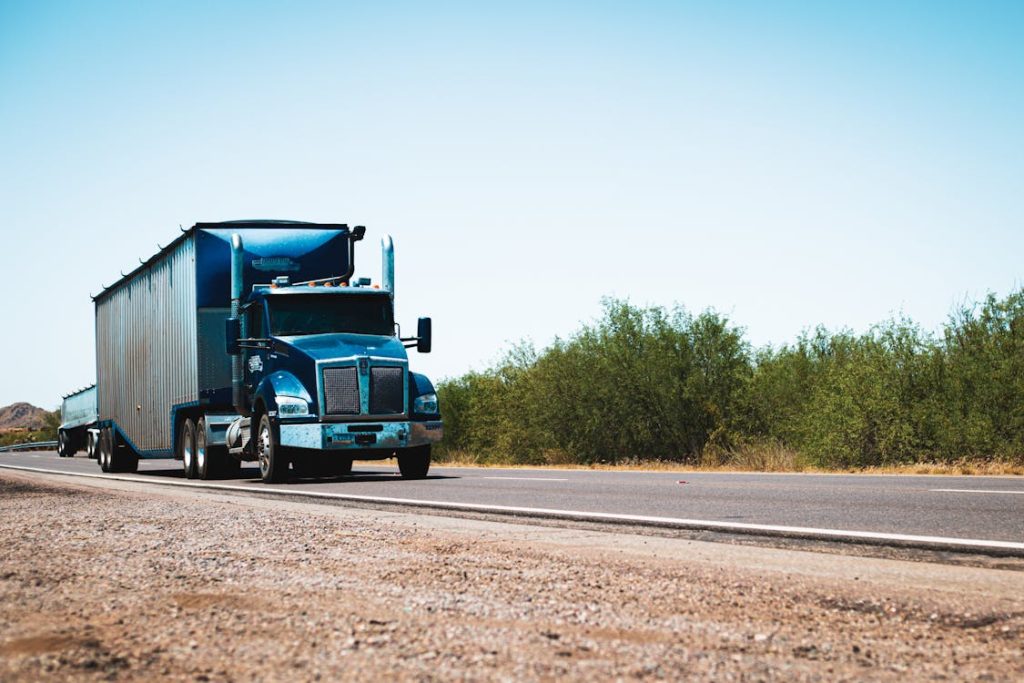 Blue semi truck driving on highway - freight factoring services in Georgia