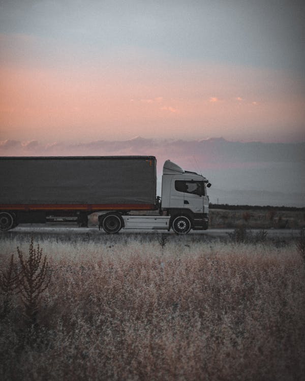 Cargo truck on highway at sunset - freight factoring vs bank loans for truckers